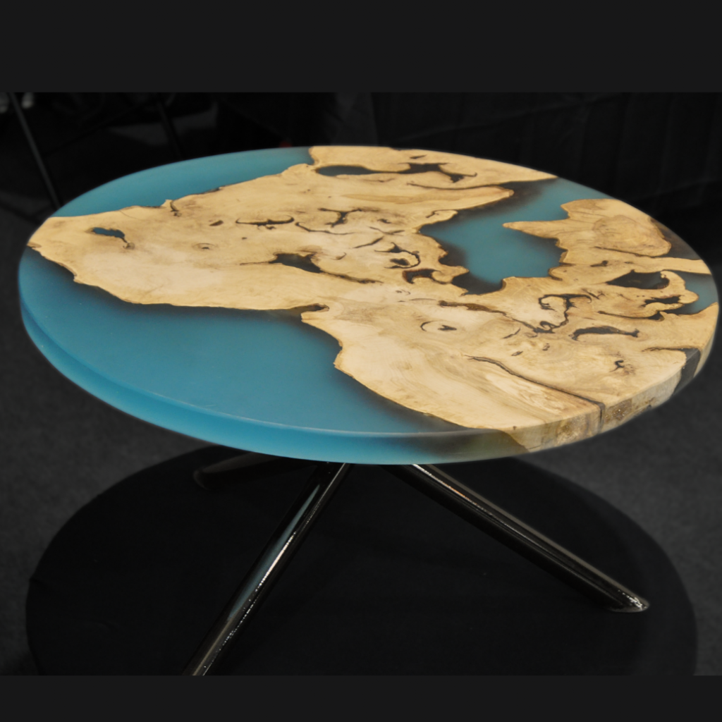 table basse ronde en bois et résine époxy bleue transparente, fixée sur un pied mikado en tube rond métal noir vernis