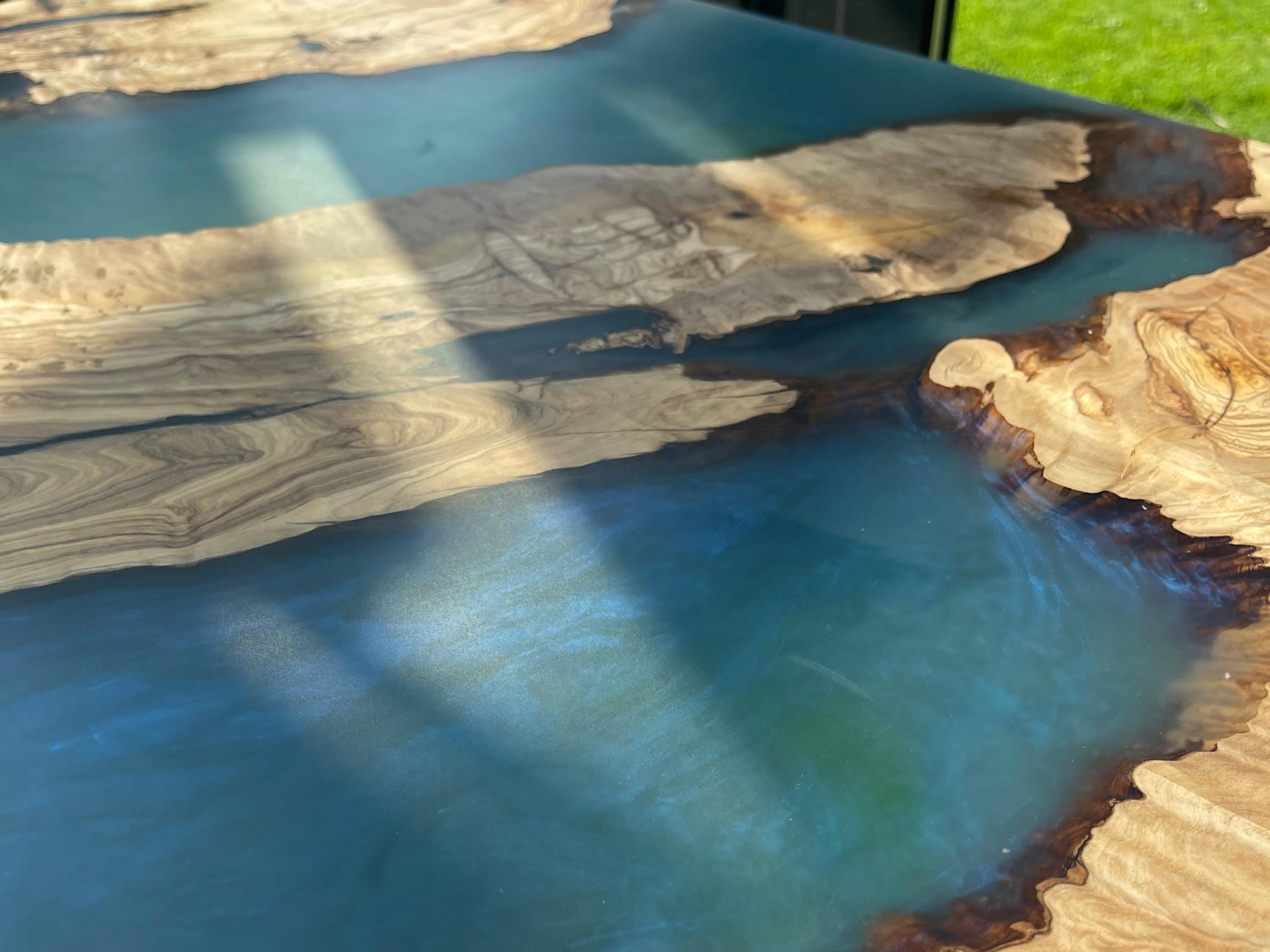 zoom résine époxy - Table bois et résine époxy - olivier et résine bleu vert - pied mikado - PRENN AOUR