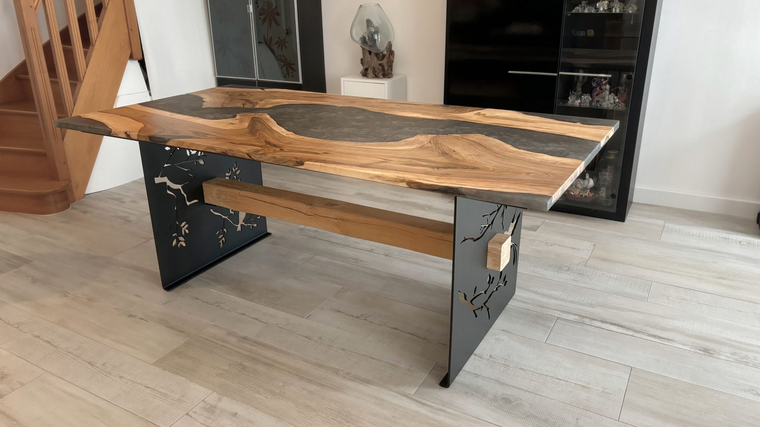 Table de salle à manger en bois et résine époxy - gris métallisé - bois noyer - pieds en tôle gravée d'oiseaux - passage d'une poutre en chêne